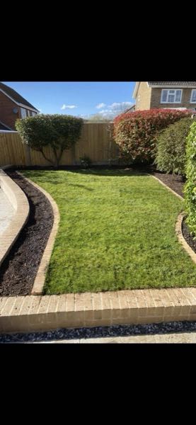 New lawn laid with block-paved edging and freshly mulched curved borders in a Bedford garden